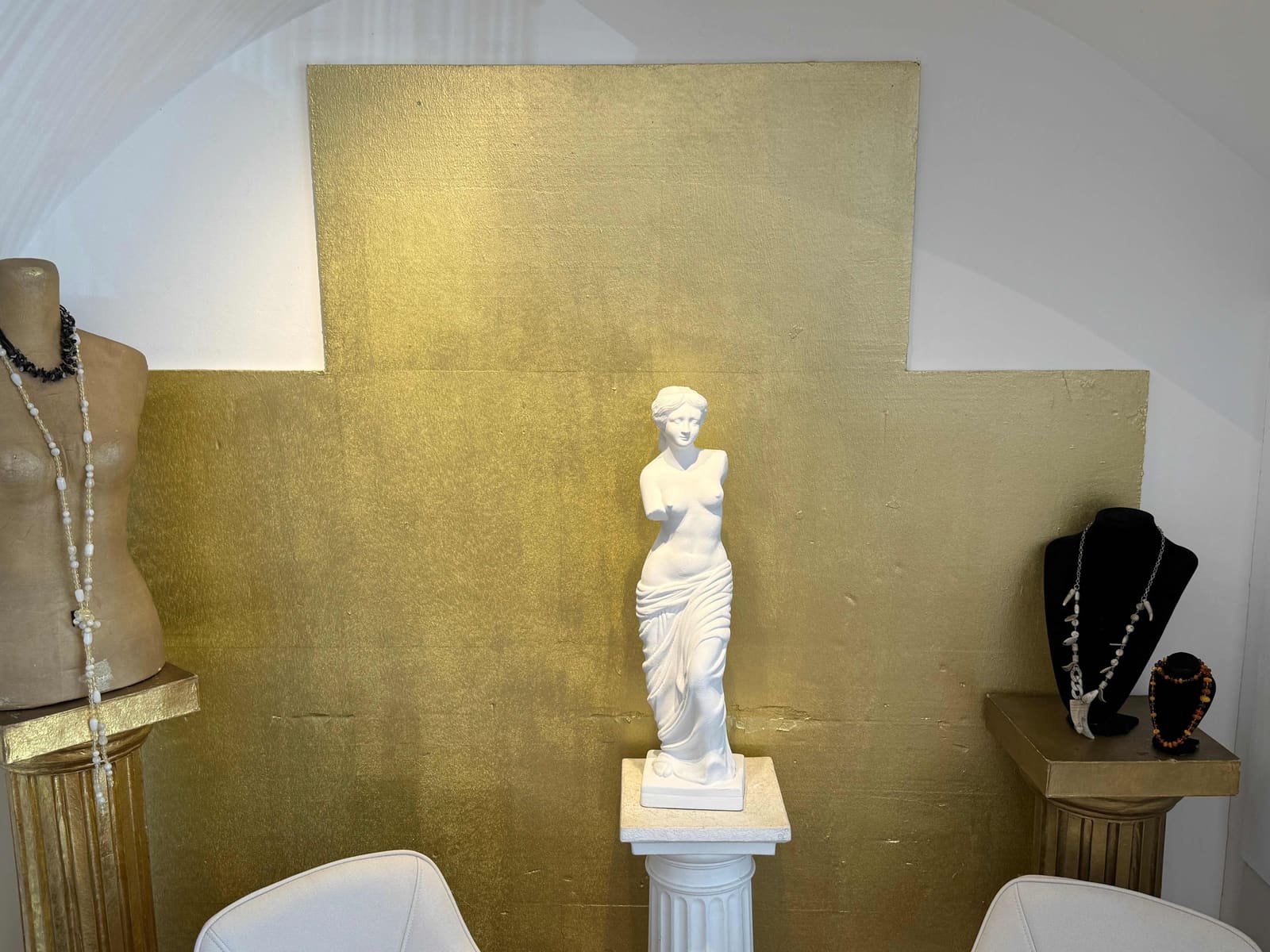 Verkaufsraum von Aurello in Mödling mit goldener Wand und Venus-Statue